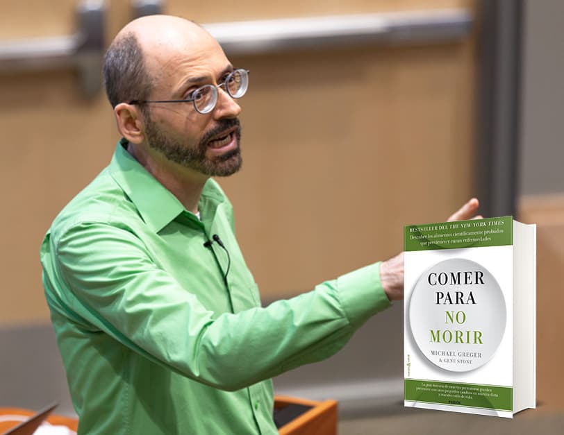 El Dr. Greger con una camisa verde y gesticulando hacia la audiencia
