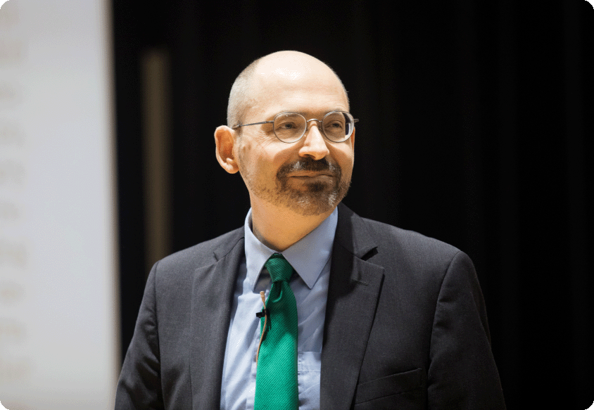 El Dr. Greger en un escenario sonriendo al público