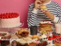 woman sitting at table full of desserts