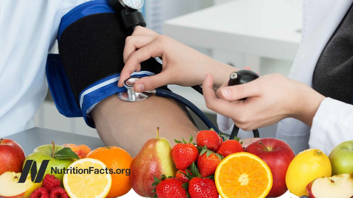 nurse taking blood pressure with fruit on the bottom of photo