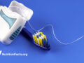 toothbrush and floss against blue background
