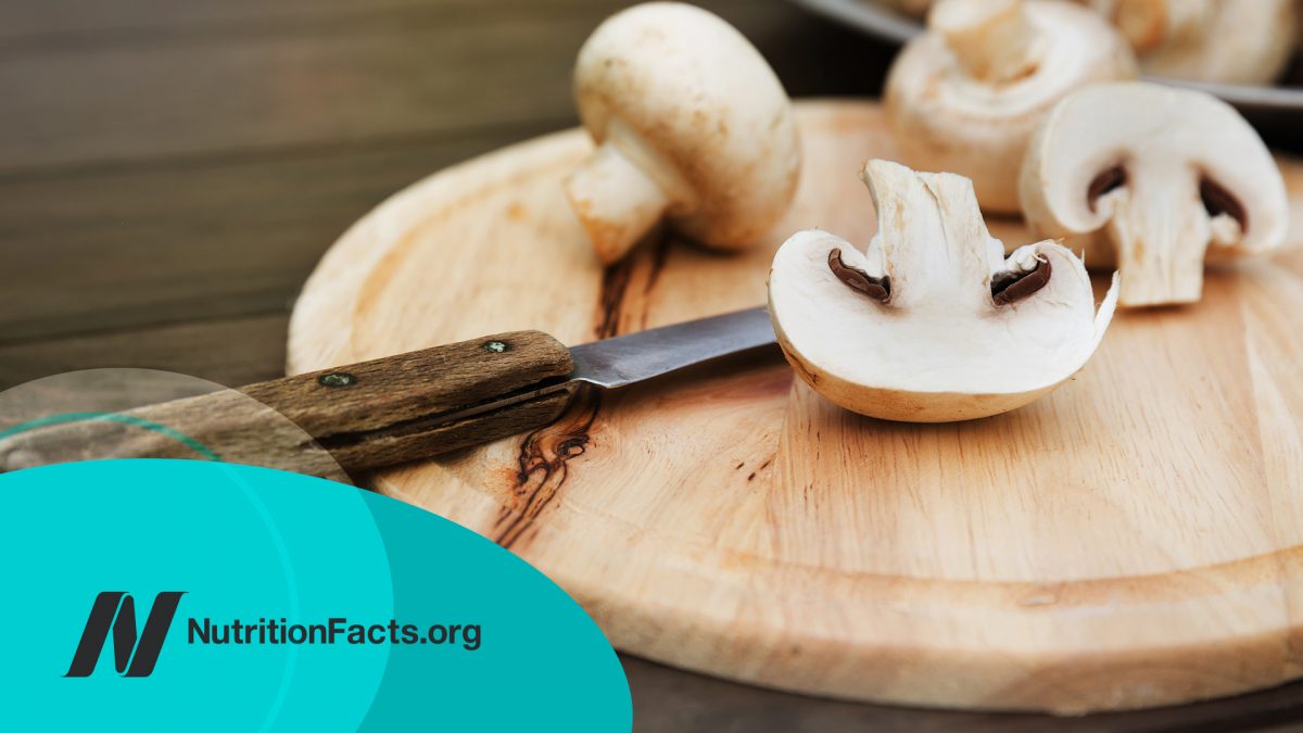 Fresh white mushrooms on a wooden background