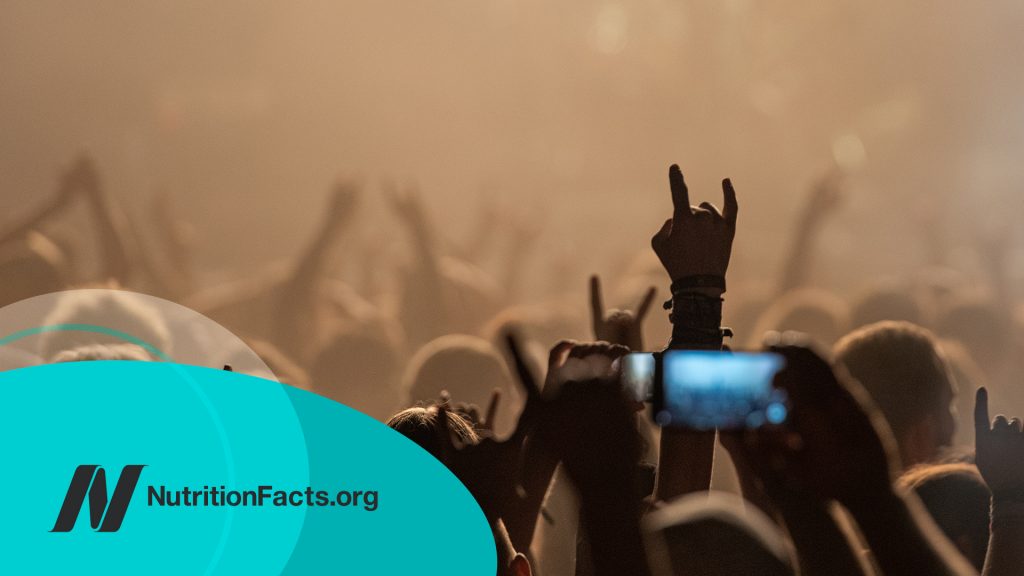 Hand raised with a rock sign above the crowd at the heavy metal concert