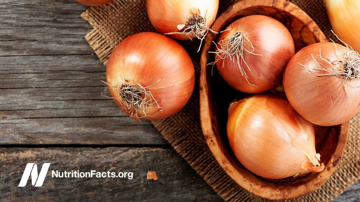 Fresh raw onions on wooden background