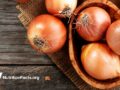 Fresh raw onions on wooden background