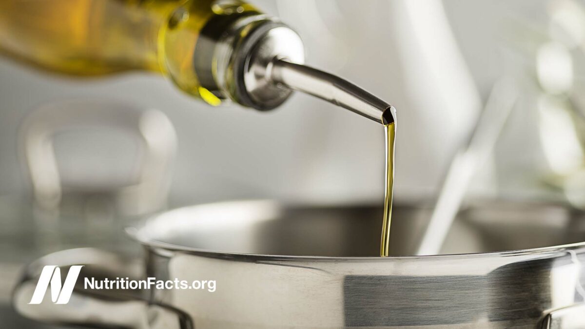 Cooking oil poured from a bottle into a steel pot