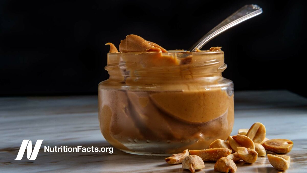 glass jar of peanut butter on dark background