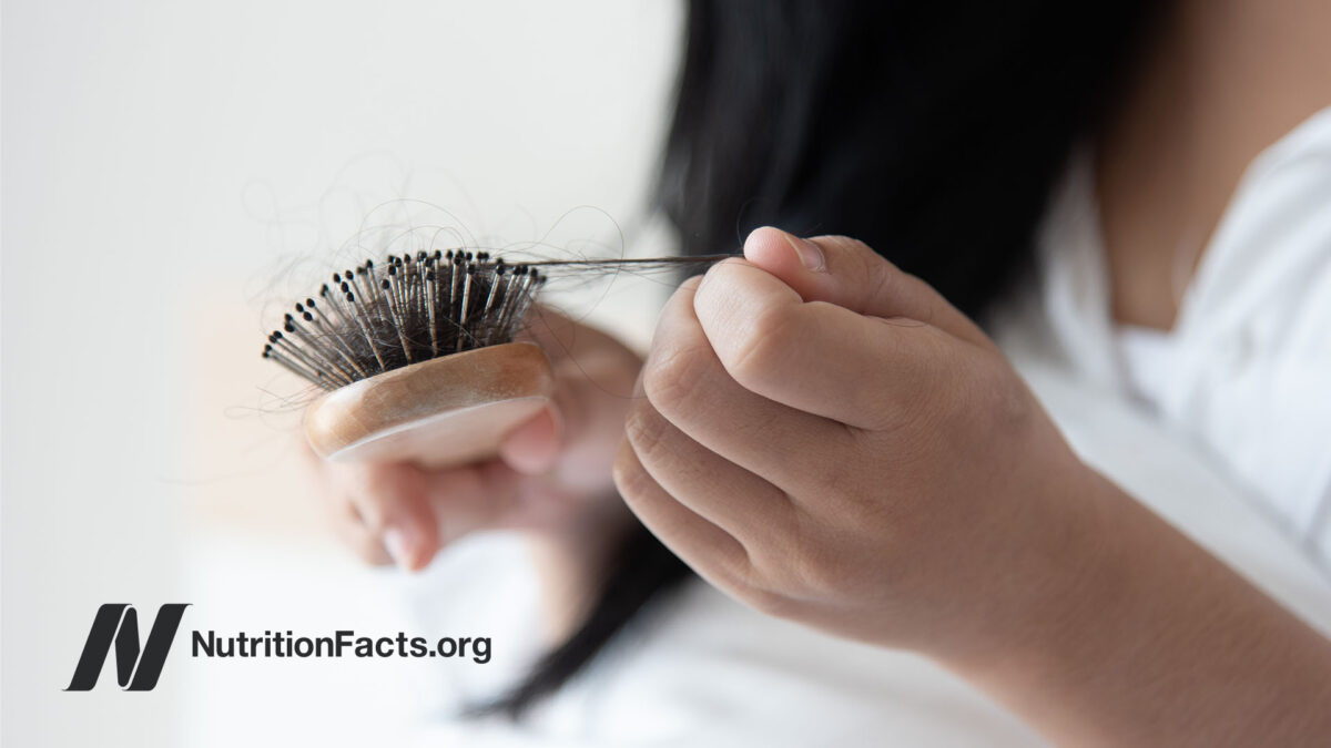 woman looking at her hairbrush with hair
