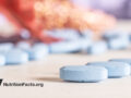 Blue vitamin tablets on white surface