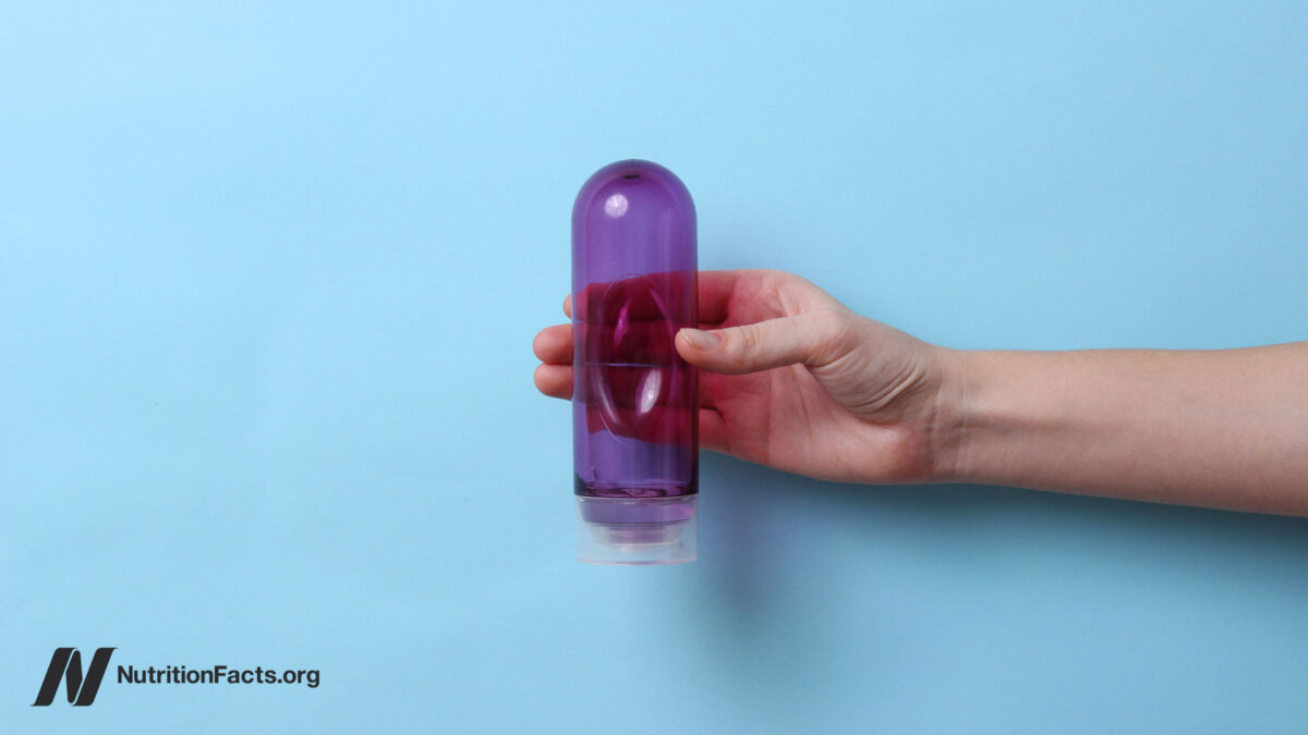 An intimate lubricant in a female hand on a blue background