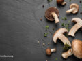 Flat lay composition with fresh wild mushrooms on black table