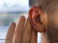 Young man with hearing problems, hearing loss or hard of hearing