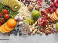 Assortment of veggies, fruit, green leaves, grains and cereals, seeds and nuts