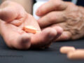 hands holding supplement pills