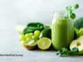 a green juice surrounded by green fruits and veggies