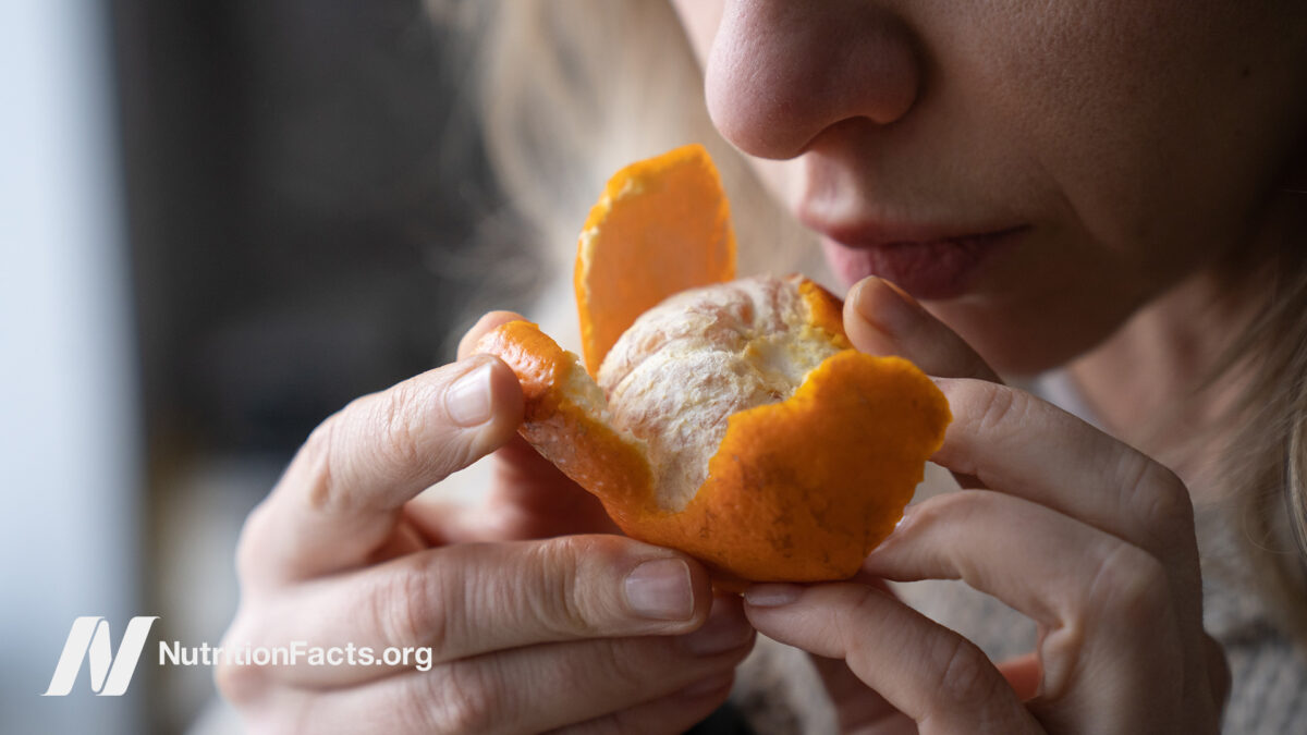 Woman sniffing an orange