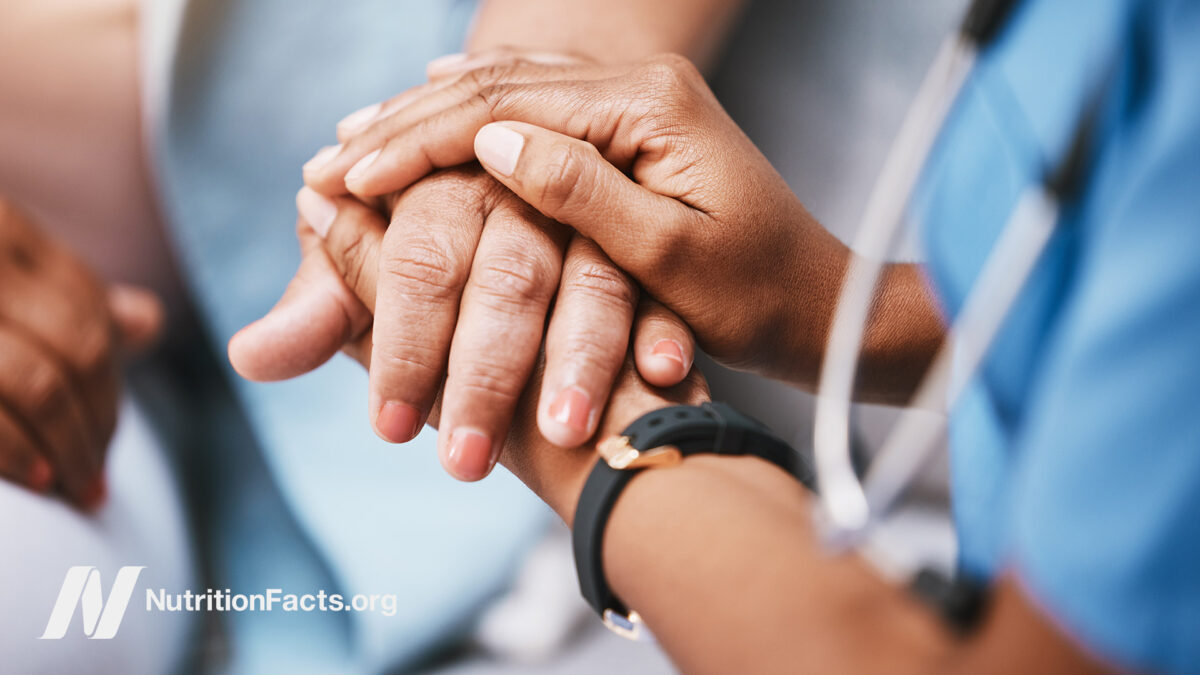 A medical professional holding the hand of a patient