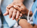 A medical professional holding the hand of a patient