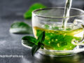 Green tea in a glass mug on a table outside