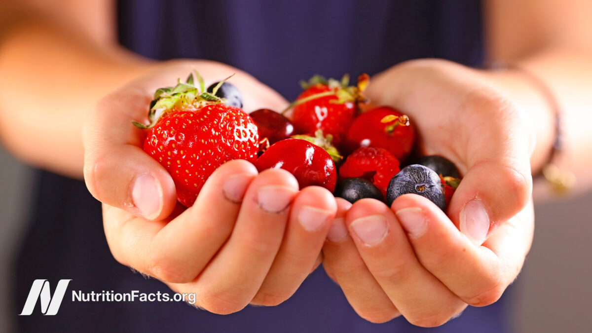 person holding a variety of berries in their hands