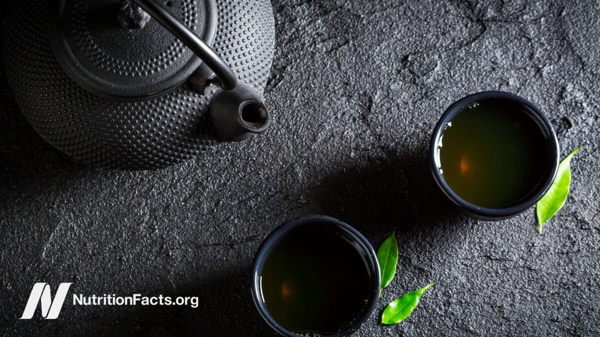 black tea pot and small tea cups filled with tea