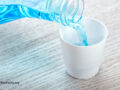 Mouthwash being poured into a small white cup