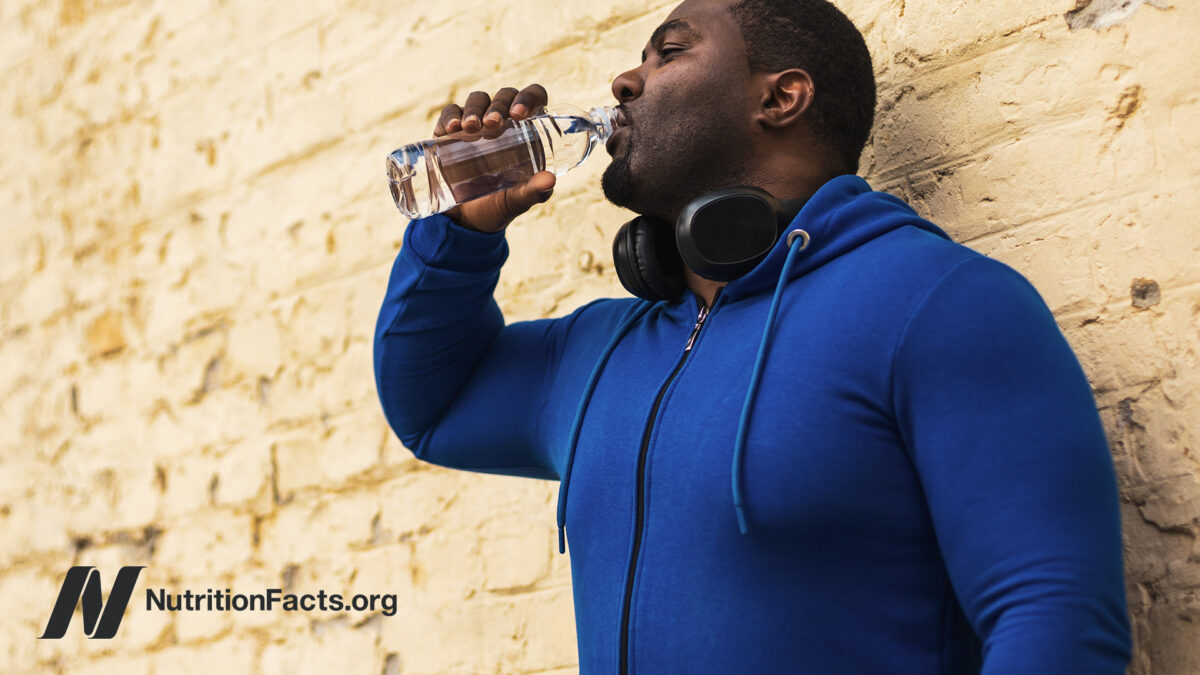 A person drinking water wearing exercise clothing