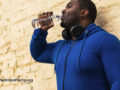 A person drinking water wearing exercise clothing