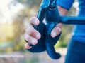 Close up shot of someone squeezing the brake on their bike handles