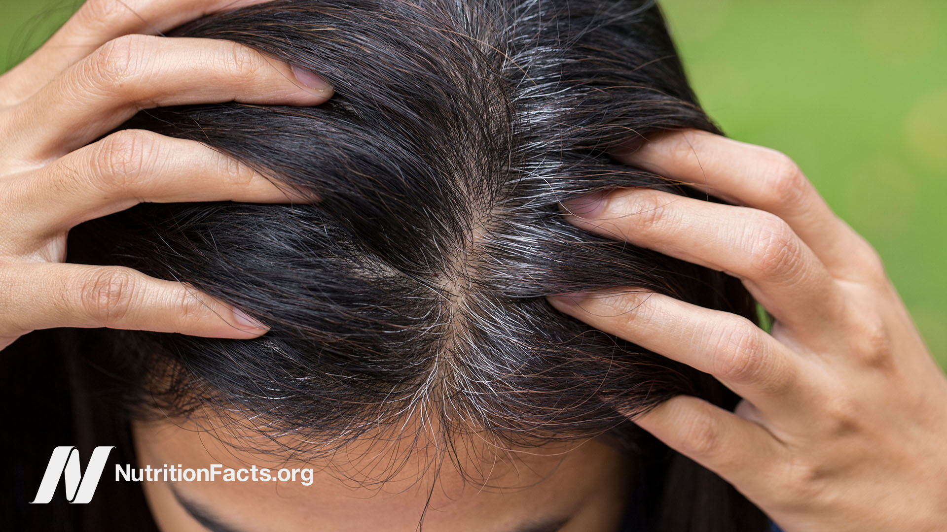 Person holding their hair apart at their scalp