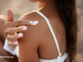 Woman applying sunscreen to her shoulder