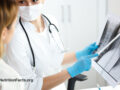 Doctor pointing and examining an x-ray of a patient with Sarcoidosis while speaking with patient