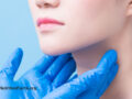 Hands with blue gloves hovering over a person’s thyroid area