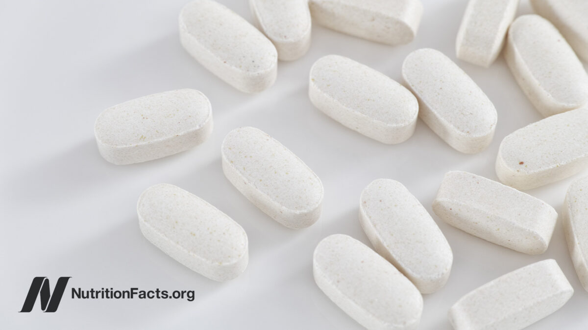 Closeup view of white tablets of taurine supplements on a white background