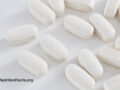 Closeup view of white tablets of taurine supplements on a white background