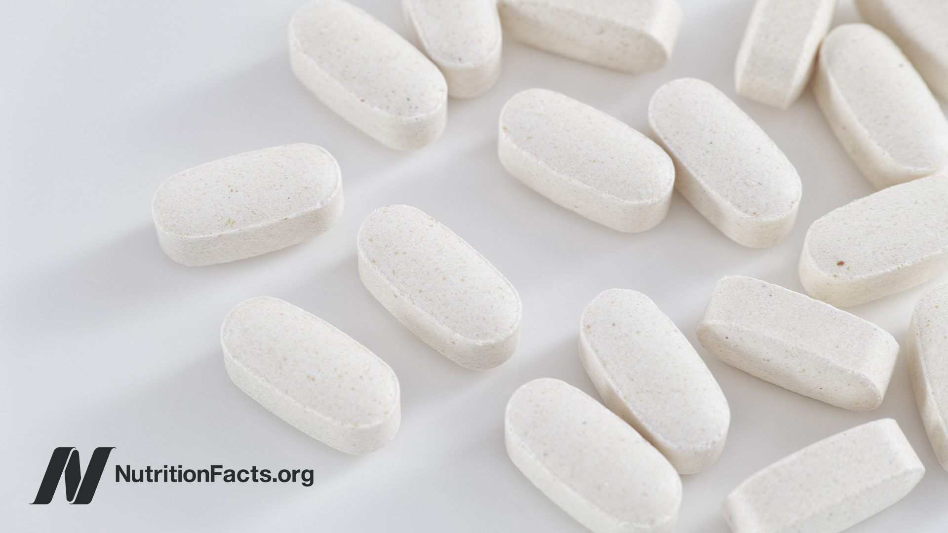 Closeup view of white tablets of taurine supplements on a white background
