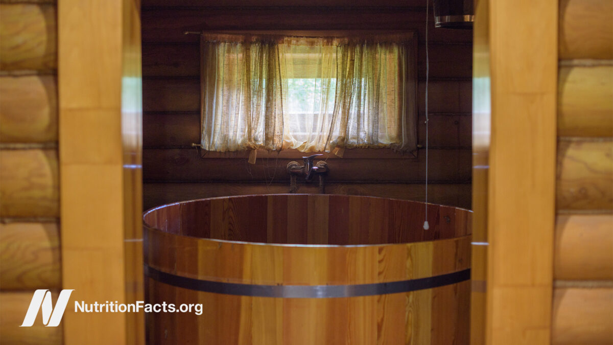 Outside view of an open wooden door looking into a wooden cold plunge tub