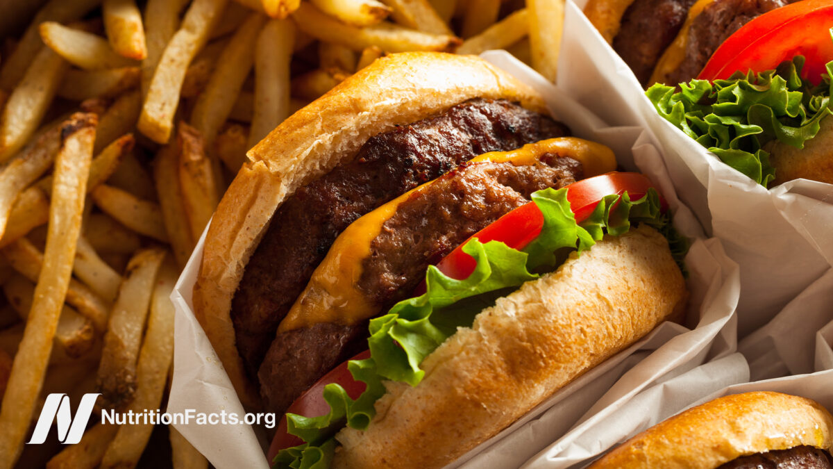 Closeup view of a double cheeseburger and a pile of french fries