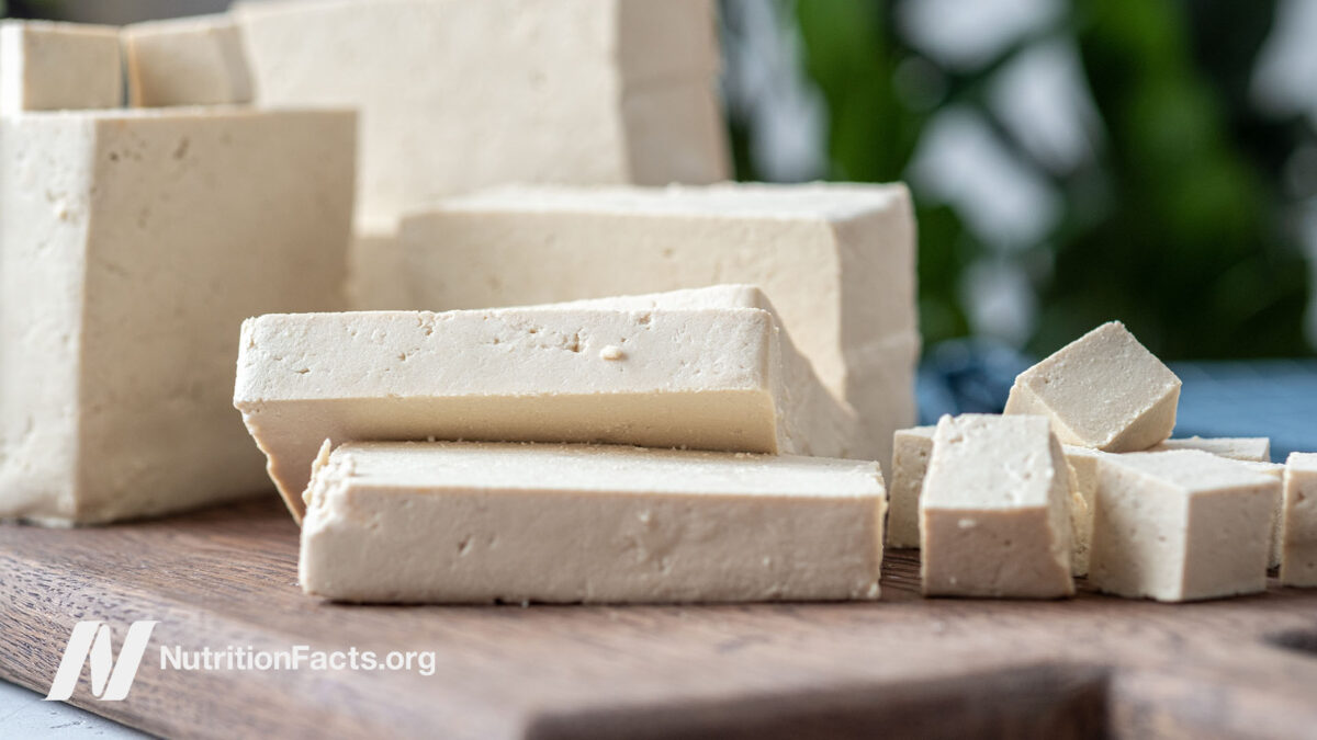 Tofu sliced and cubed on a cutting board