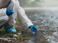 Scientist collecting a water sample from outdoors