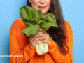Woman cheerfully holding bok choy